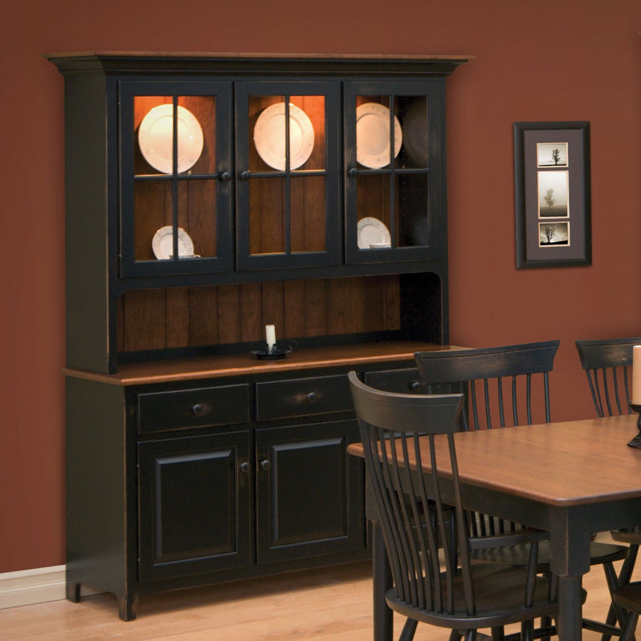 Black painted china hutch with a lighted three-door glass top, oak surface and paneled base in a red dining room