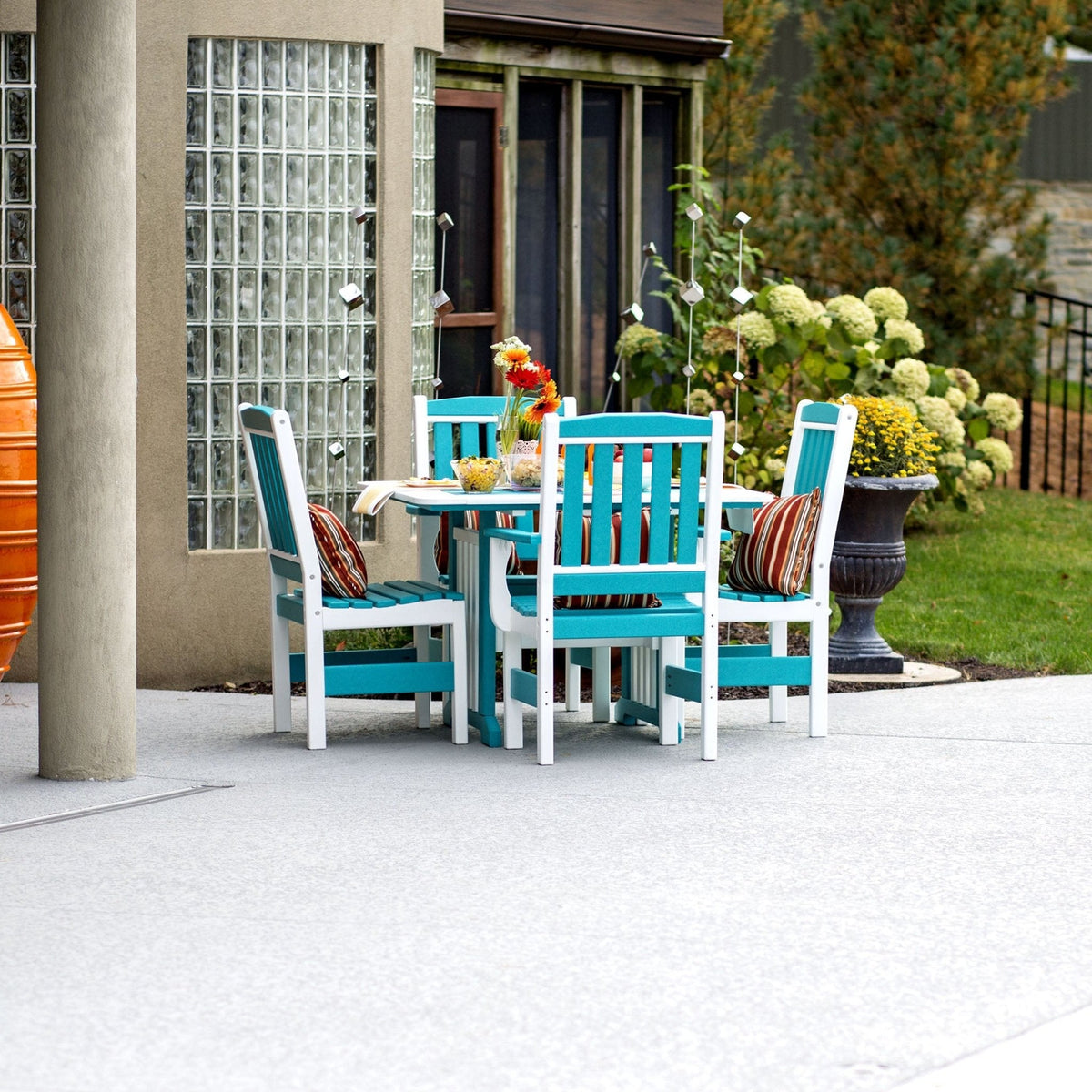 Aruba blue and white poly patio dining set with square table and four slatted arm chairs on a concrete patio by gardens