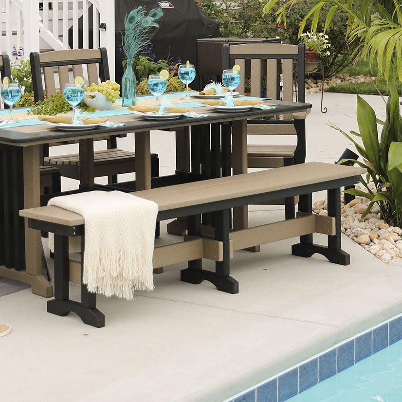 Weatherwood and black poly 6 foot backless patio dining bench with trestle legs beside a poolside dining table