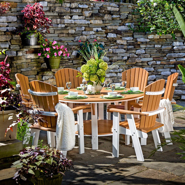 Cedar and white poly 60 inch round bistro dining table with six fan back chairs on a patio by a stone wall