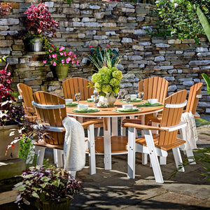 Cedar and white poly 60 inch round bistro dining table with six fan back chairs on a patio by a stone wall