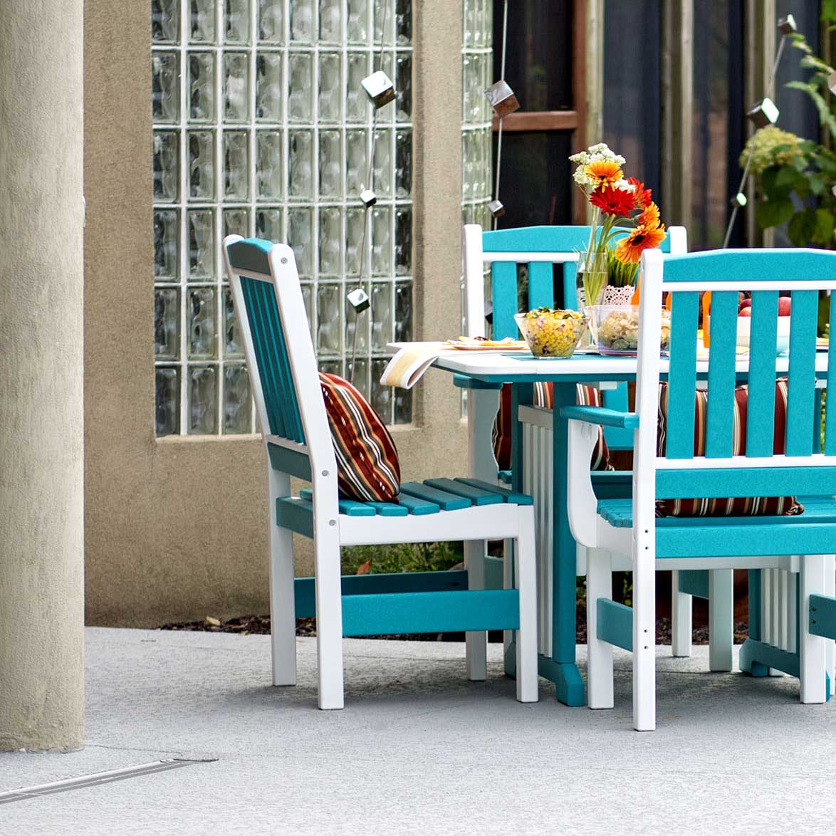 Aruba blue and white poly English Garden patio dining table with slat back side chairs and arm chairs on a patio
