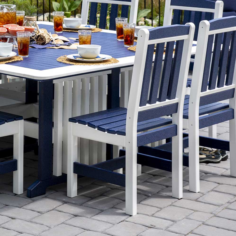 Navy blue and white poly English Garden patio dining chairs with slat backs pulled up to a set outdoor table