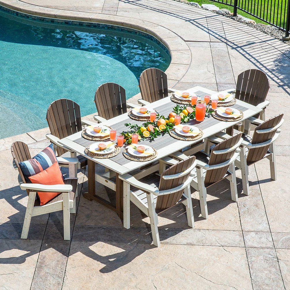Overhead view of a nine piece poly patio dining set in weatherwood and brown set with citrus and drinks beside a pool