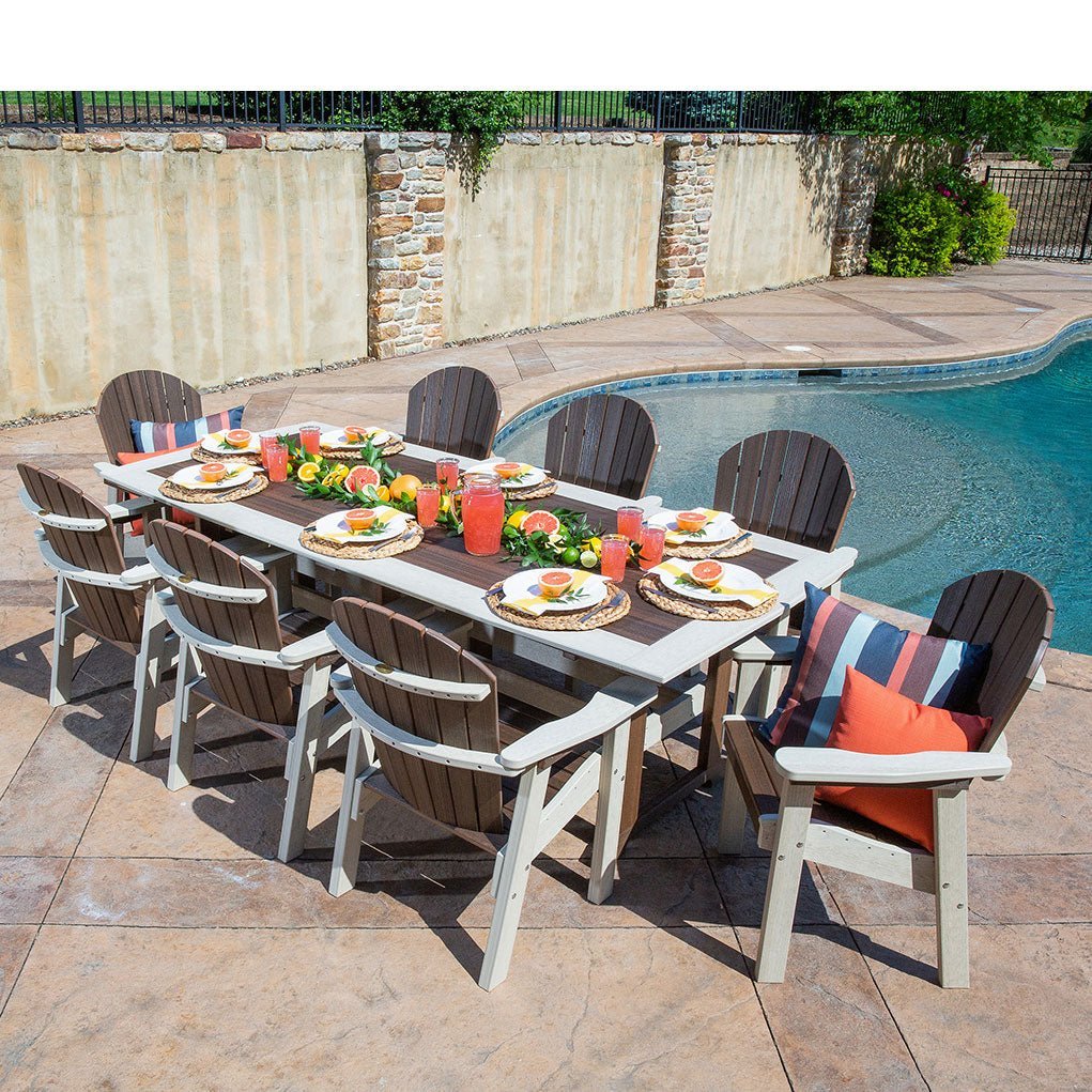 Overhead view of a nine piece poly patio dining set in weatherwood and brown set with citrus and drinks beside a pool