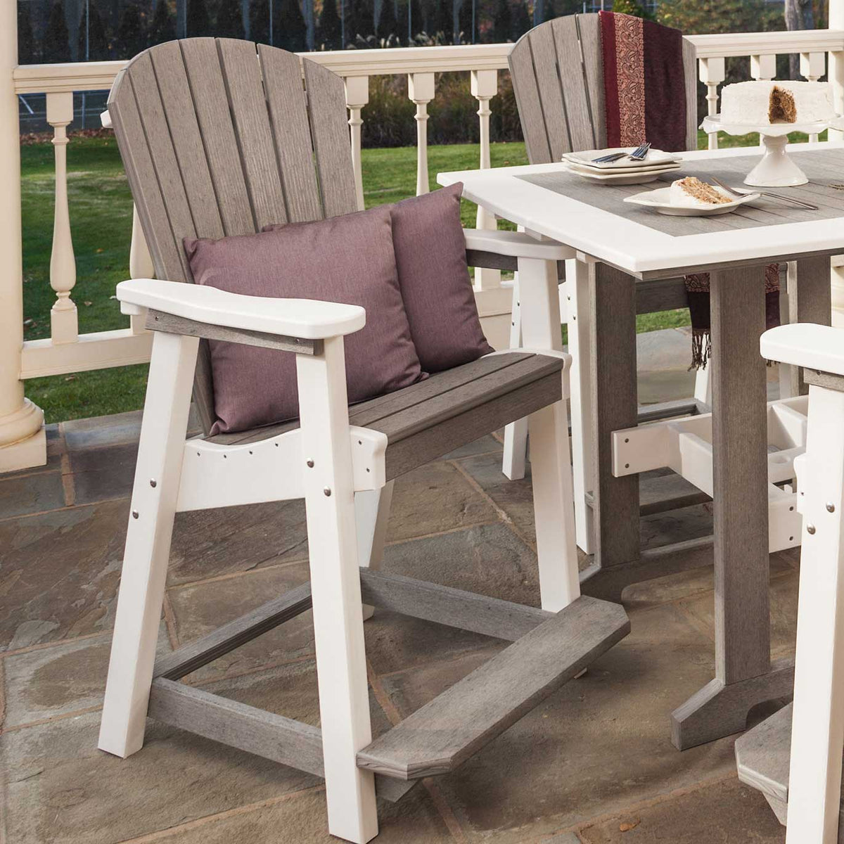 Driftwood gray and white poly counter chairs with fan backs, footrests and plum pillows at a patio table