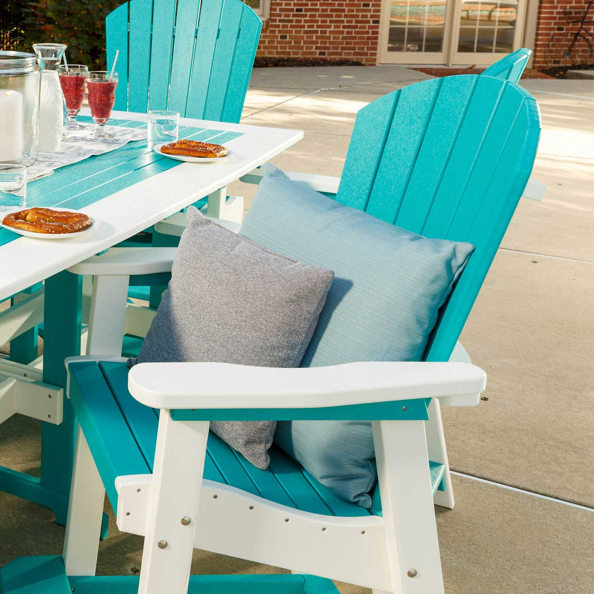 Aruba blue and white poly counter chairs with gray and blue pillows at a white patio table set with drinks
