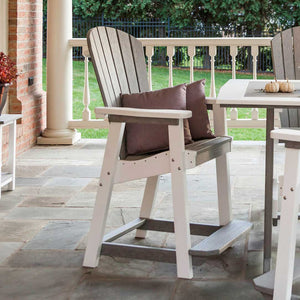 Gray and white poly counter chair with a brown pillow at a pub table on a flagstone porch in fall