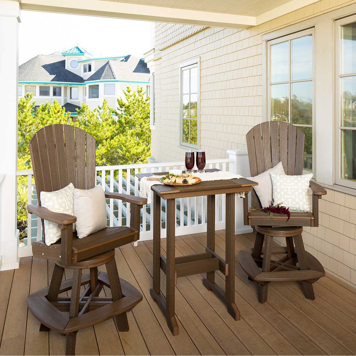 Brown poly counter table with two swivel Adirondack chairs, wine and a cheese board on a coastal porch