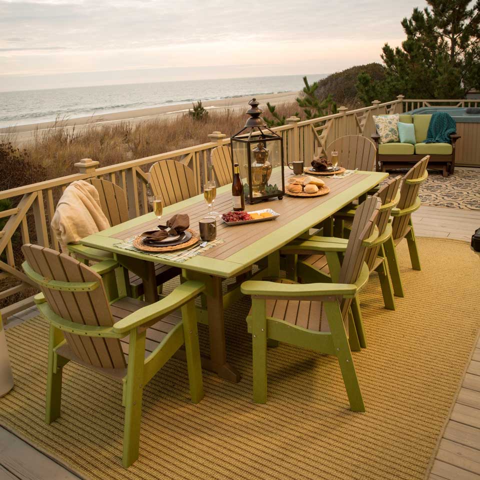 Lime green and cedar poly dining table with six arm chairs on an oceanfront deck set with wine and appetizers