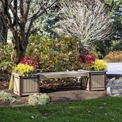 Weatherwood and brown poly planter bench with two square planter boxes of colorful foliage under a tree