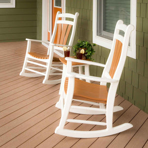 White poly rocking chairs with cedar contoured seats and back slats beside a table with iced tea on a deck