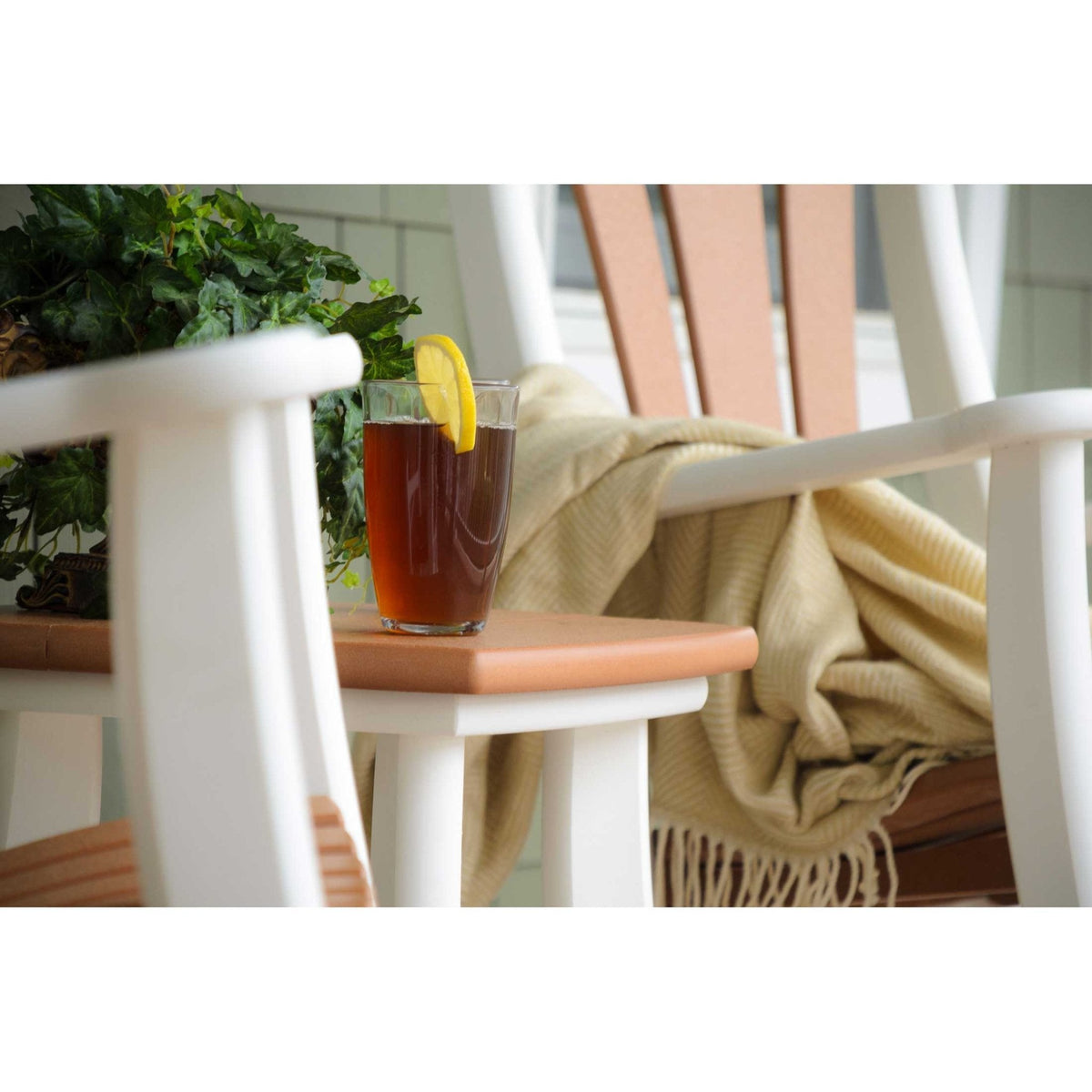 Iced tea on the cedar and white poly side table set between two white rocking chairs with a throw