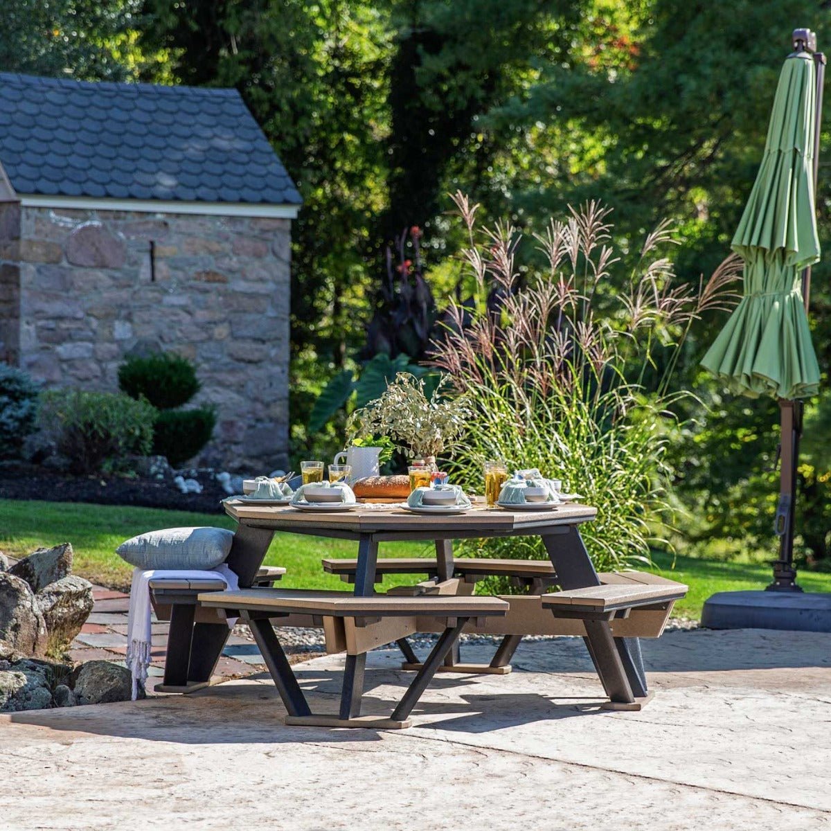Weatherwood poly octagon picnic table with black frame and four benches under a green umbrella on a patio