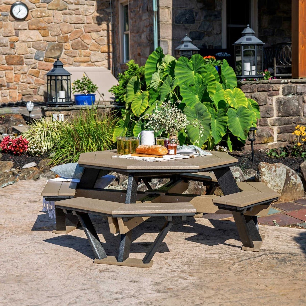 Octagonal weatherwood poly picnic table with black legs and four benches styled with flowers and lemonade
