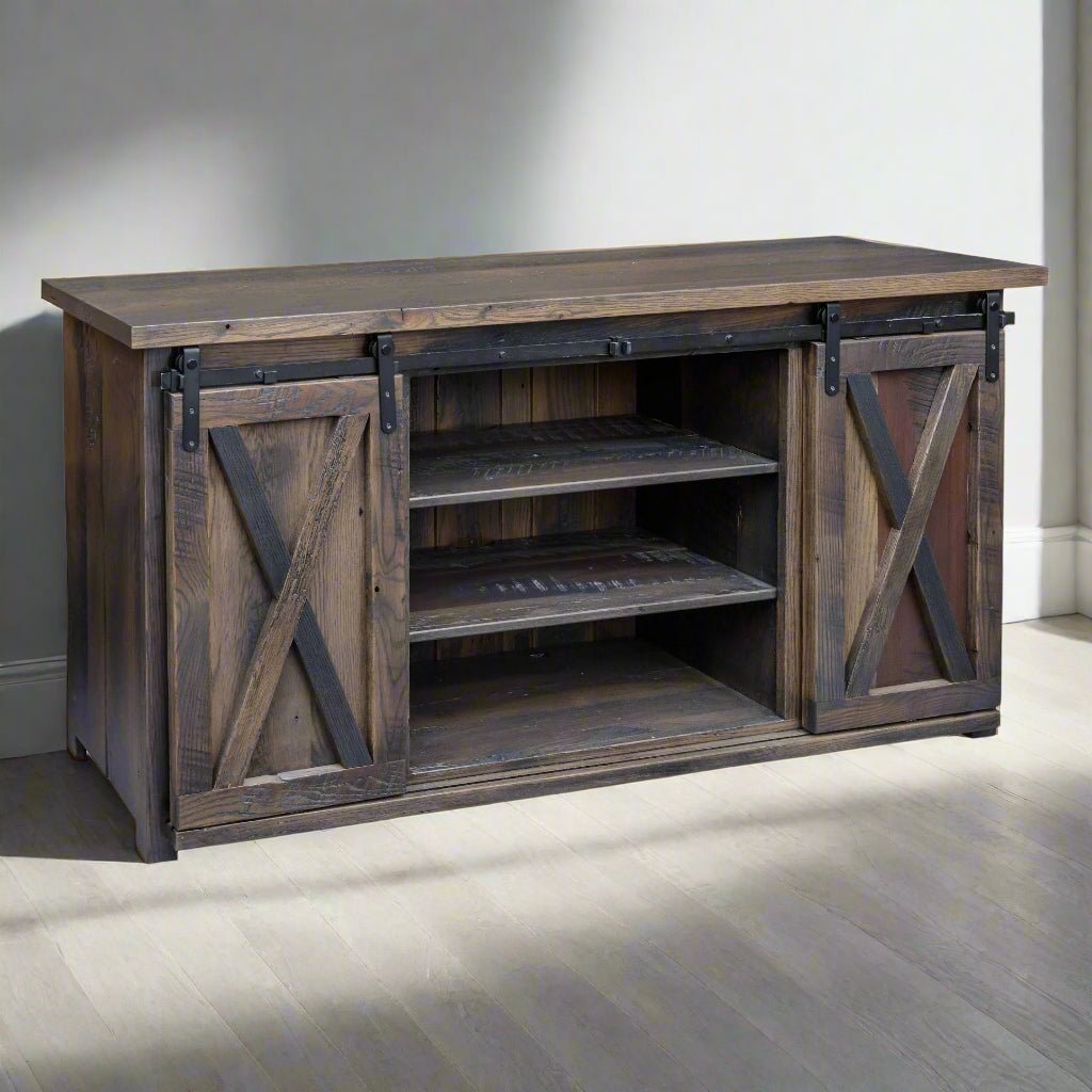 Reclaimed wood tv stand in a gray brown finish with two sliding X barn doors and two open center shelves