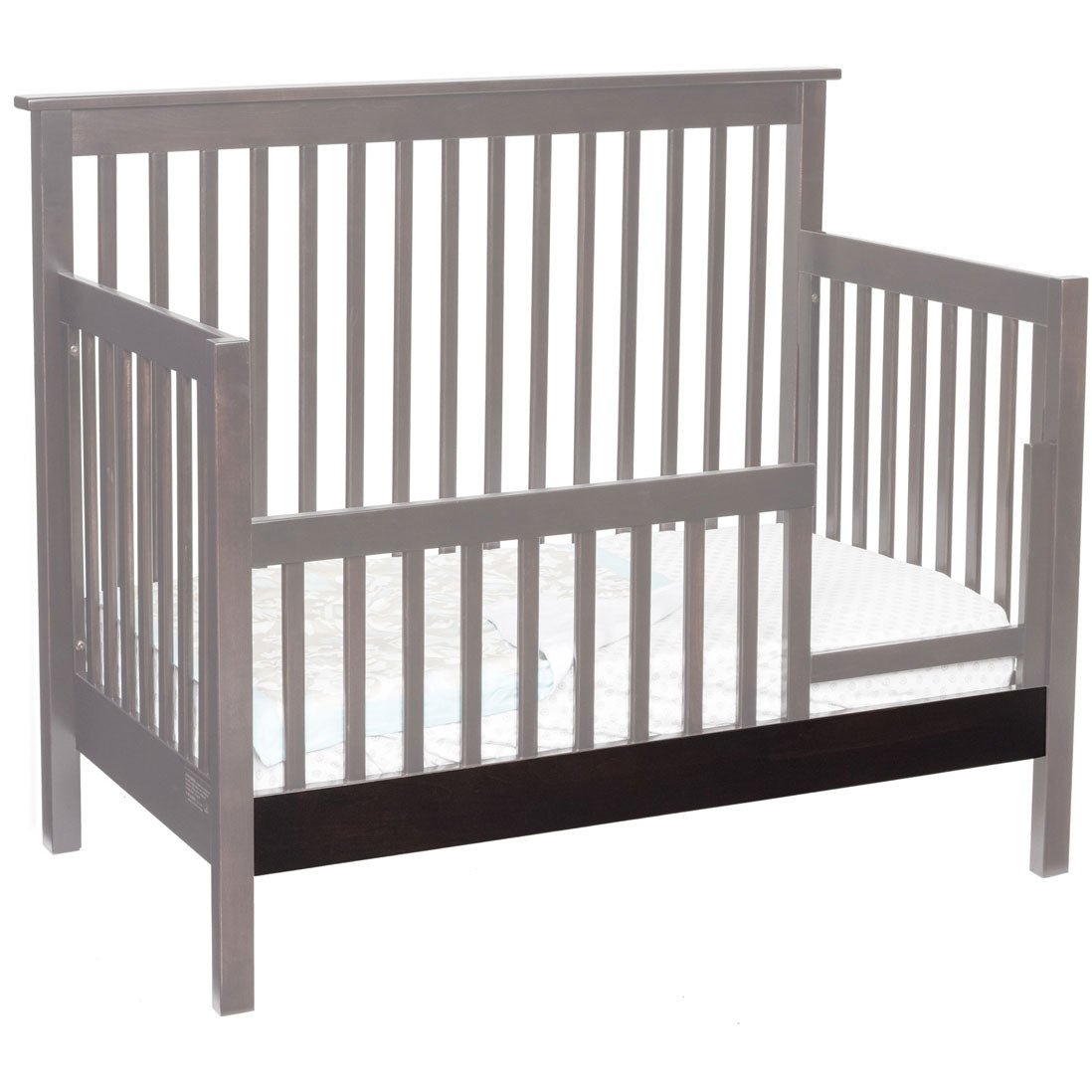 Gray crib converted to a day bed with a dark stained conversion board across the lower front