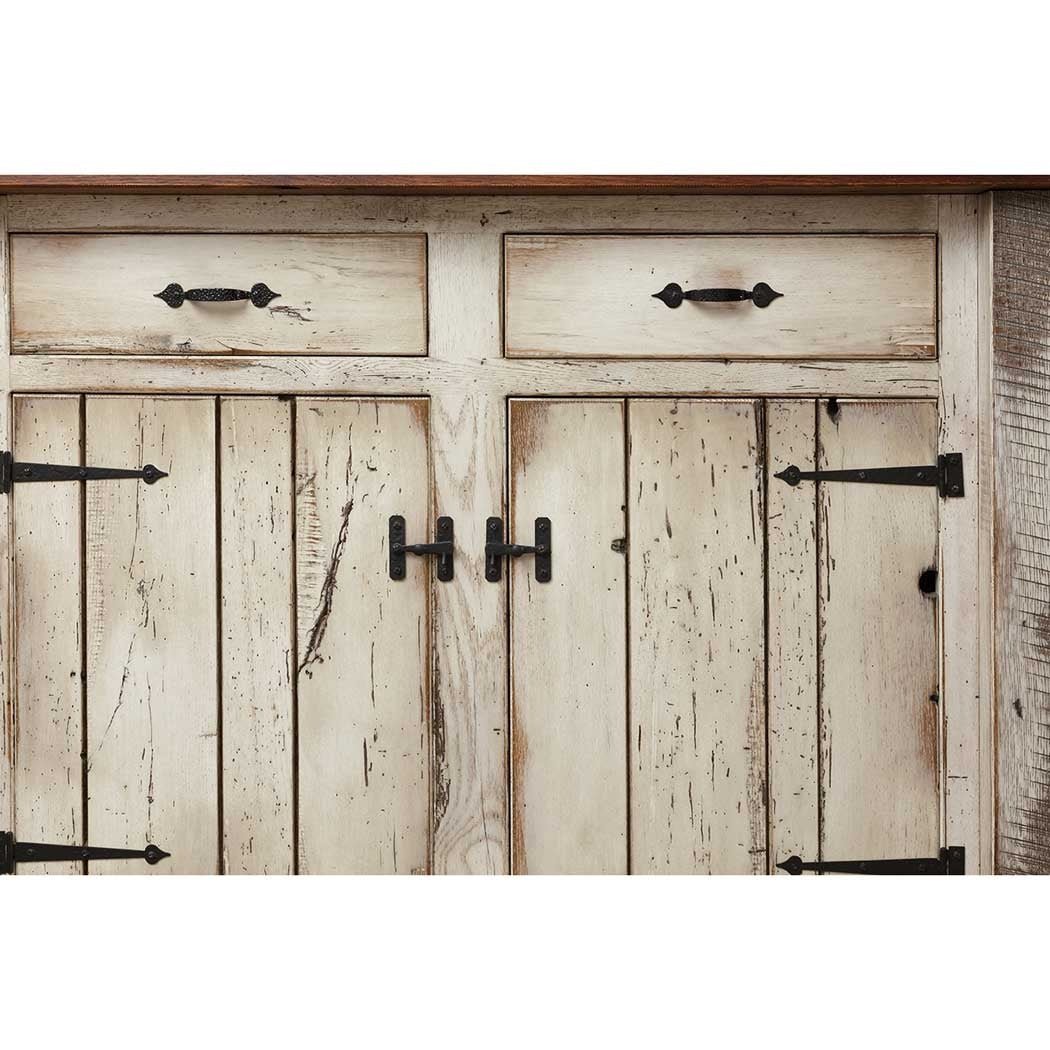 Close up of the island's whitewashed plank doors and drawers with black iron pulls and T shaped latches