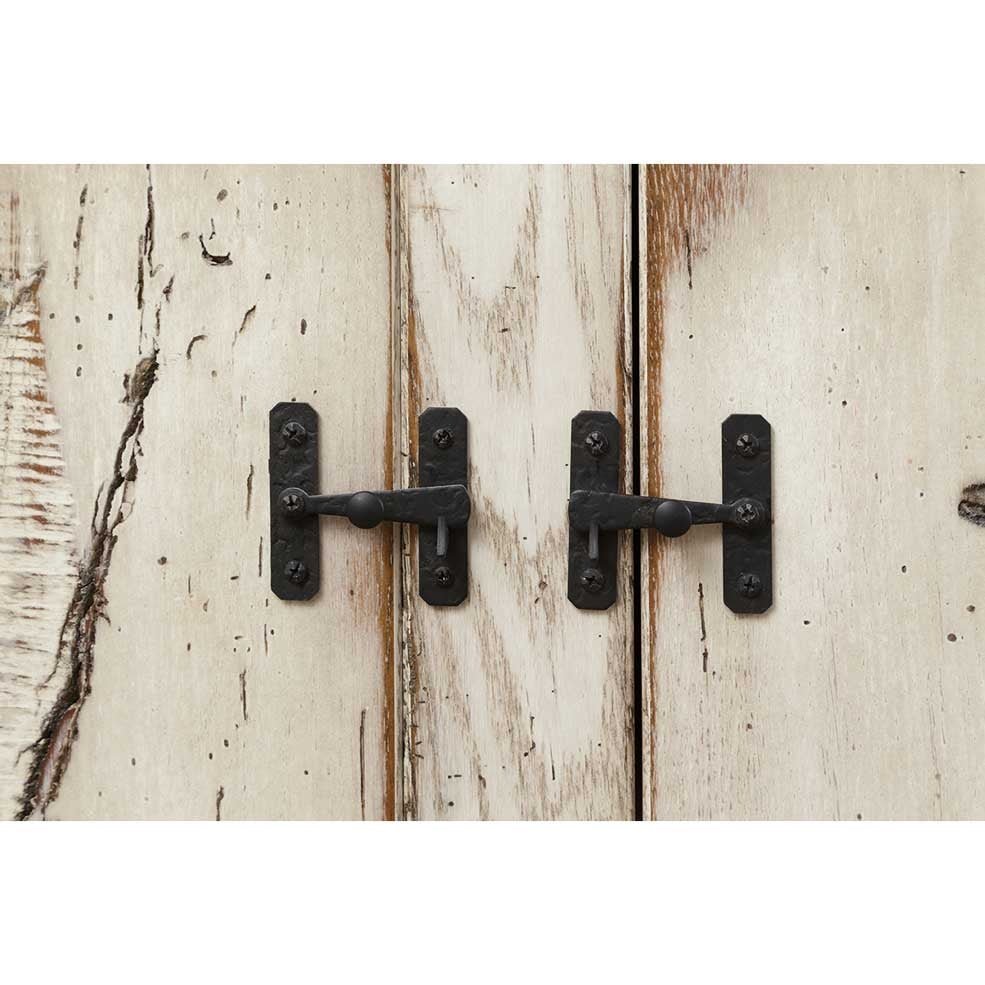 Detail of the black hand forged double door latches on the island's weathered white plank doors