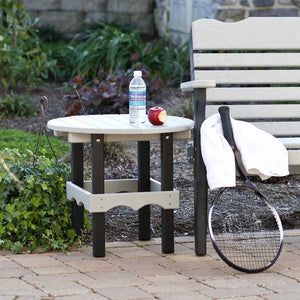 Driftwood gray and black poly round side table with water bottle and apple, beside a matching garden bench