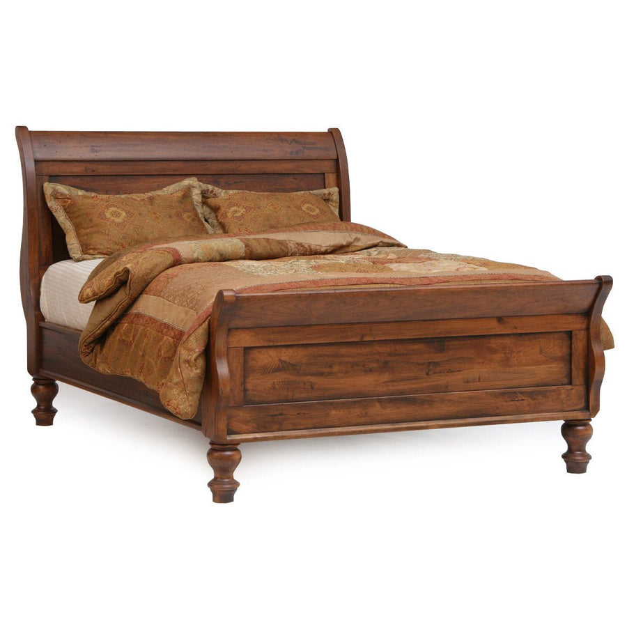 Rustic cherry sleigh bed with curved headboard, raised panel footboard and gold patterned bedding