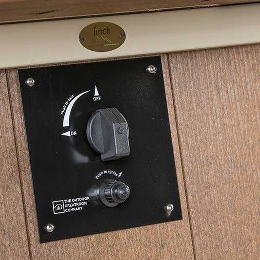 Detail of the black control panel on a poly fire pit table with push-to-turn gas knob and push-to-ignite button