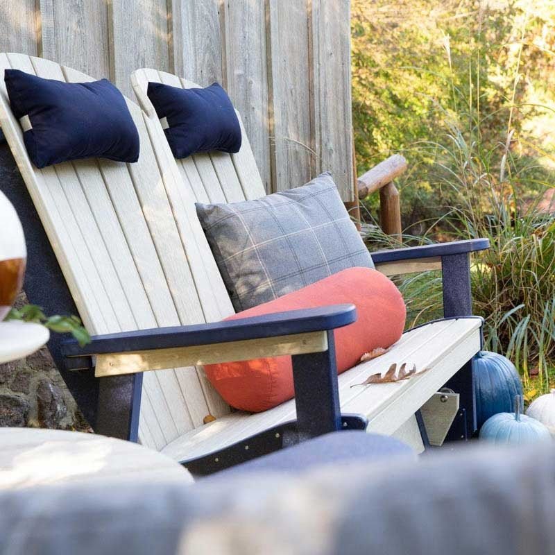 Angled view of the outdoor poly glider showing the weather-resistant slat back, wide armrests and glide mechanism in a fall garden