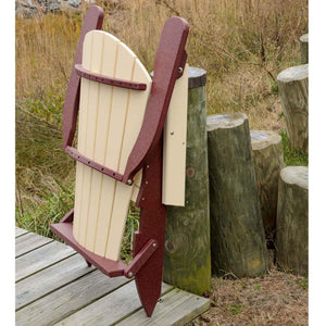 Ivory and cherry folding poly Adirondack chair shown folded upright and leaning against a piling by a boardwalk