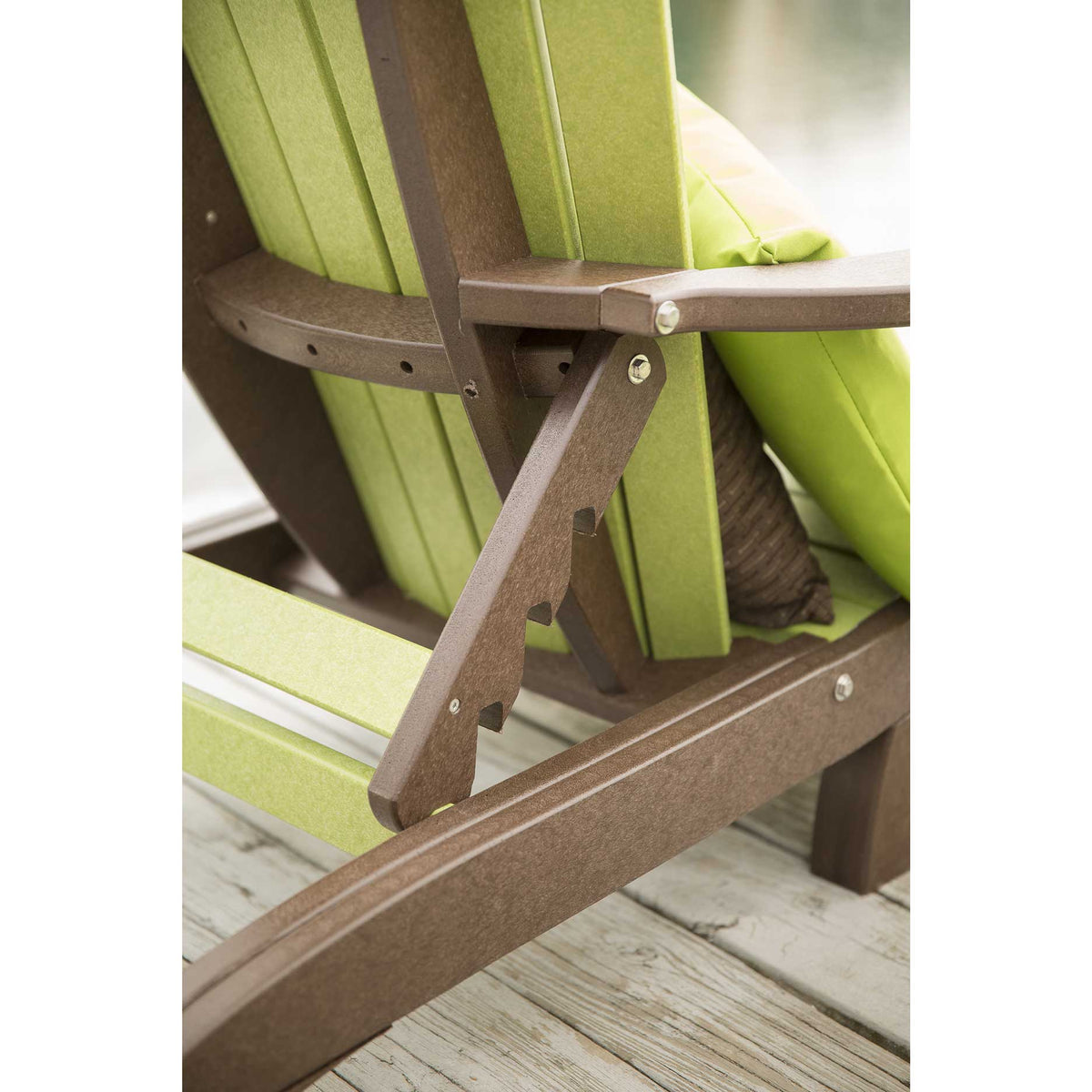 Close-up of the notched brown poly ratchet arm that adjusts the reclining back on a lime green chaise lounge