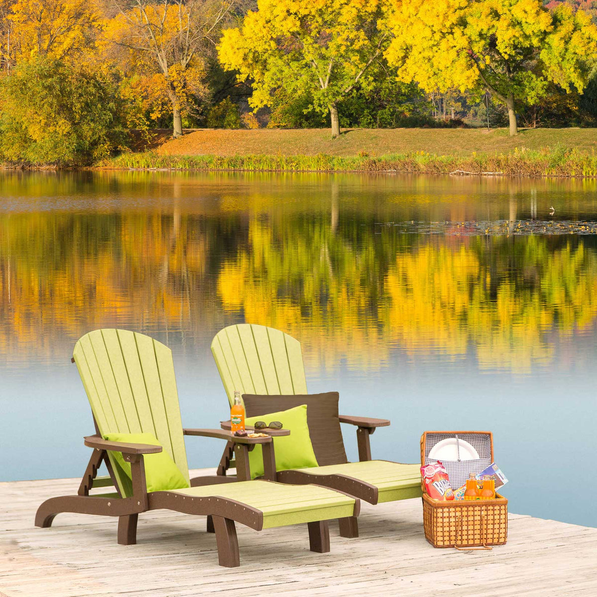 Pair of lime green and brown poly sun lounge chairs with a center table on a dock facing autumn foliage