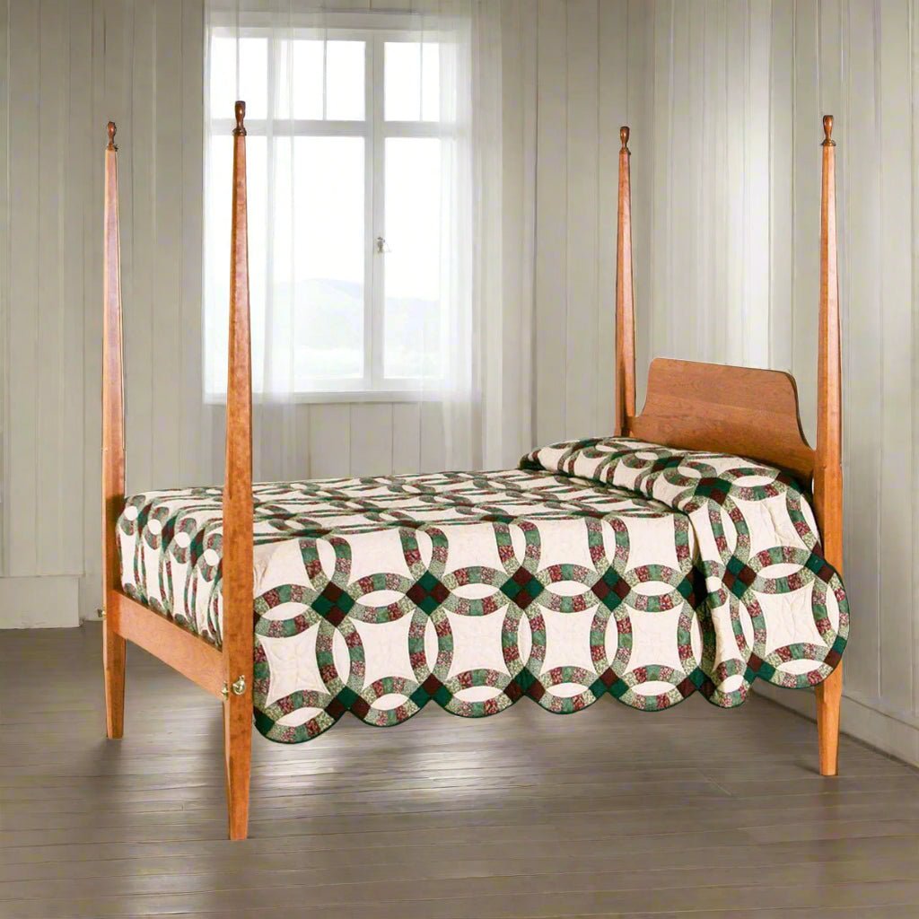 Cherry four drawer bedside chest beside a pencil post bed with wedding ring quilt in a colonial room