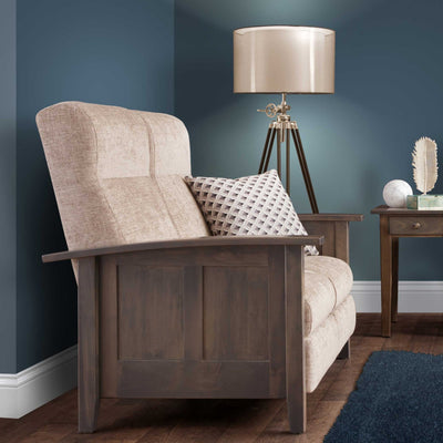 Gray stained Shaker recliner loveseat in cream chenille with a lattice pillow, paneled arm and lamp table behind