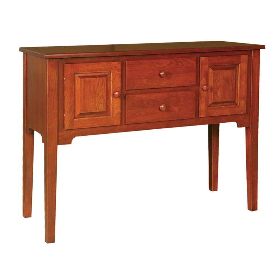 Solid cherry dining sideboard with two paneled doors, two stacked drawers with round wood knobs and long tapered legs on white