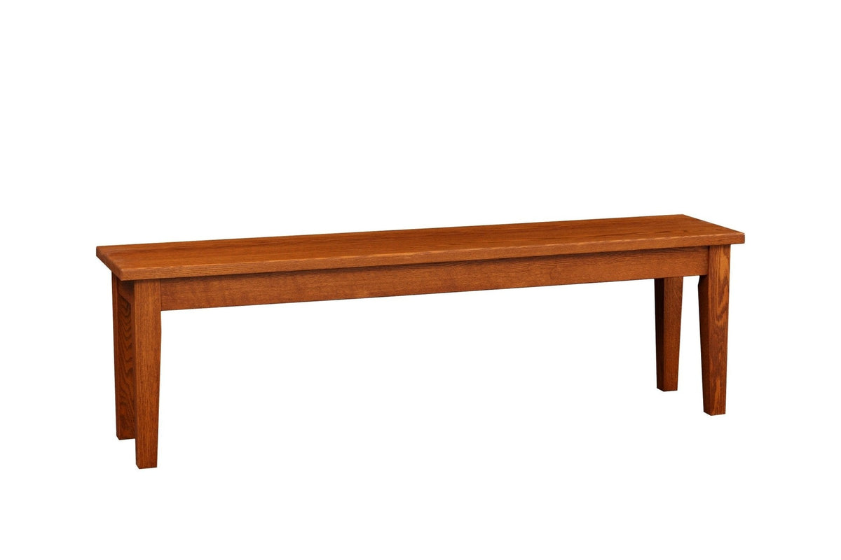 Side view of an oak Shaker dining bench with a long flat seat, plain apron and tapered legs on a white background