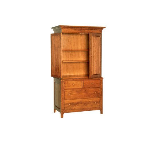 Tall cherry armoire with two raised panel doors over four drawers and crown molding beside a bed