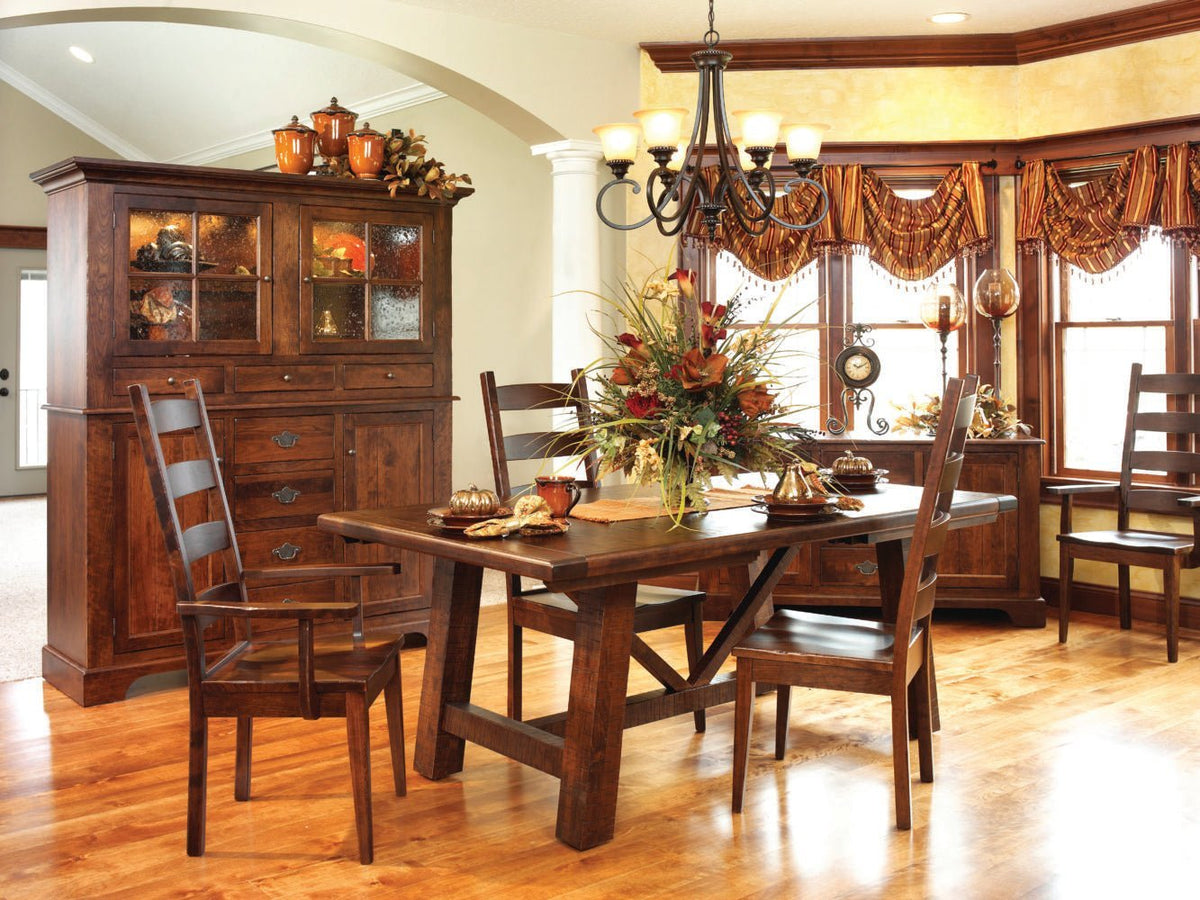 Dining room styled with a china cabinet, trestle table, ladder back chairs and a sideboard under the windows
