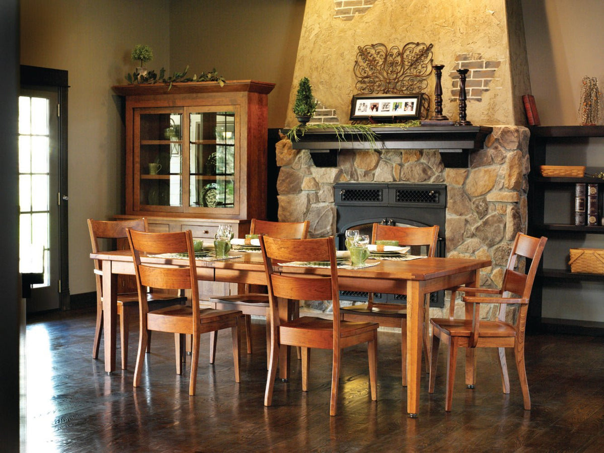Cherry dining room scene with extension leg table, six chairs, glass front hutch and stone fireplace