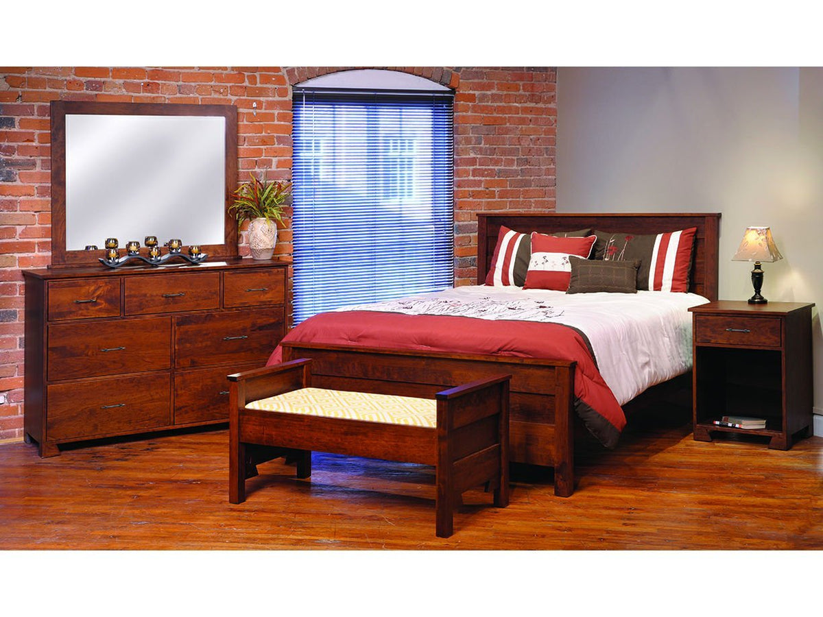 Cherry dresser and mirror shown with a panel bed, bench and nightstand in a brick loft bedroom