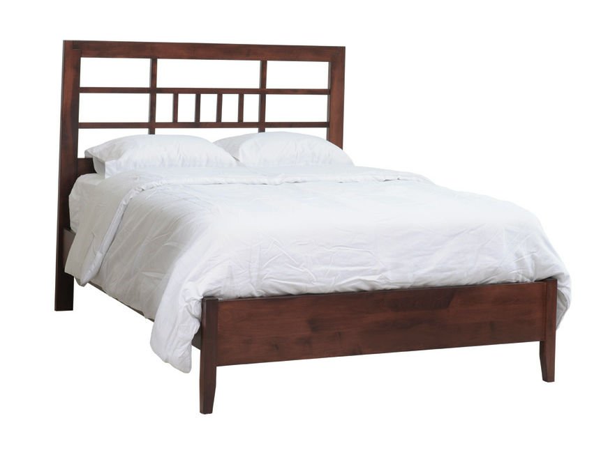 Angled view of the cherry lattice panel bed showing the geometric open headboard, white bedding and low tapered footboard