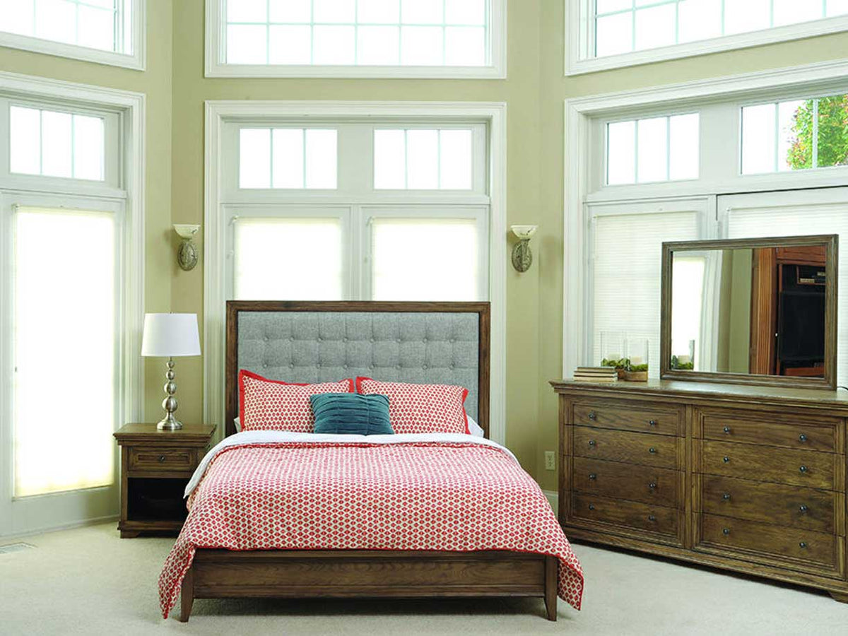 Warm bedroom vignette pairing the Santa Ana chest collection with a tufted upholstered bed and mirrored dresser