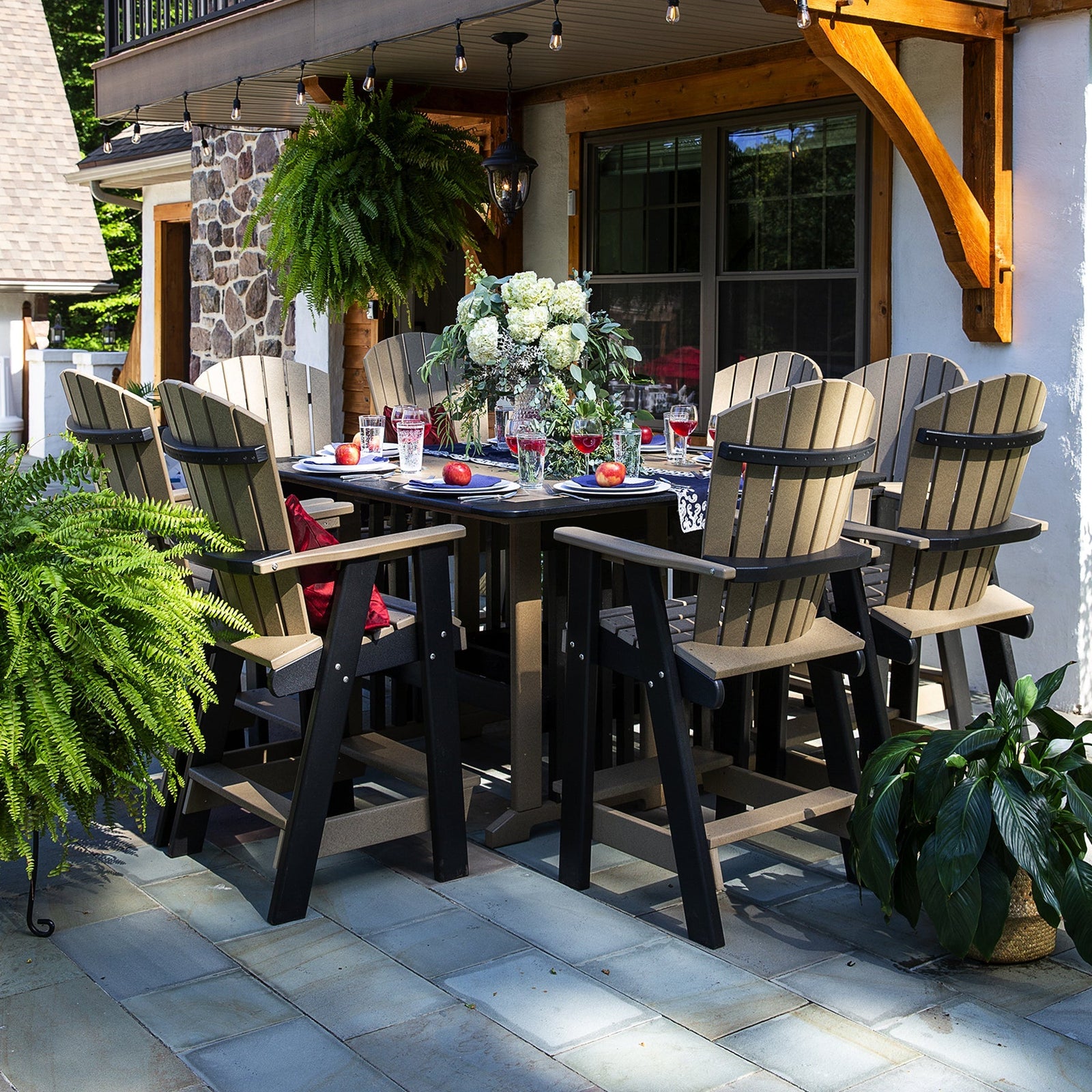 Weathered wood and black poly bar height table set with six fanback swivel chairs on a marina waterfront deck
