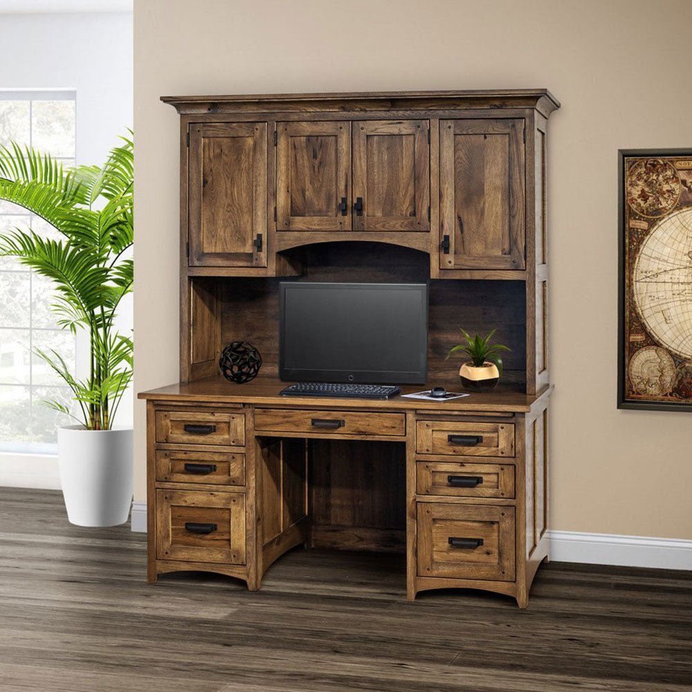 Rustic hickory kneehole desk with hutch top, arched cabinet doors, six drawers and monitor in a warm home office