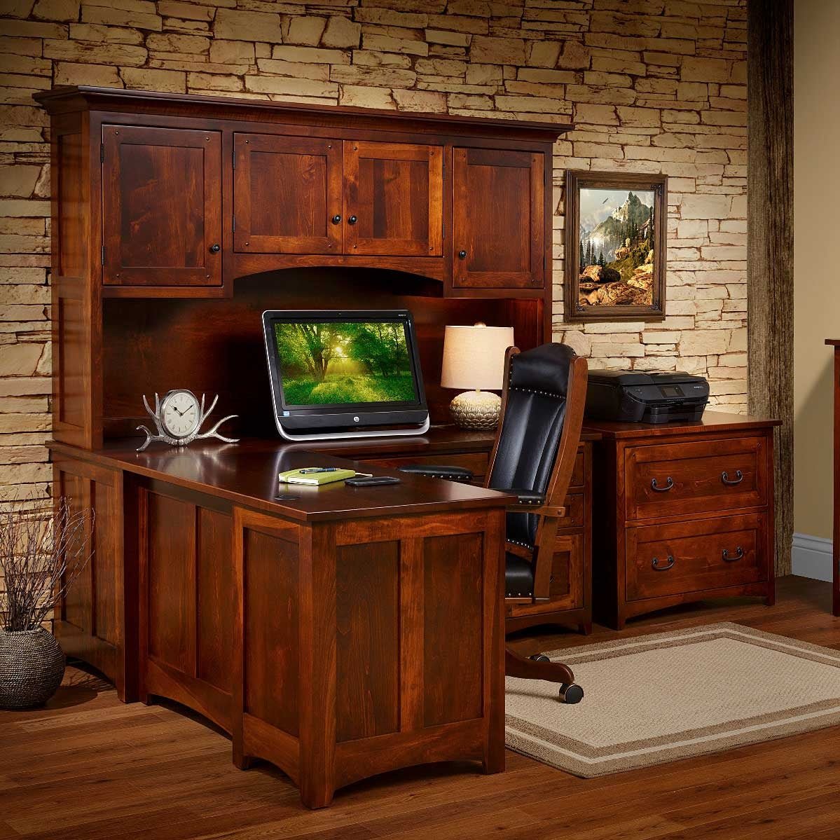 Dark cherry L shaped desk with hutch cabinets, leather chair and lateral file in a stone walled office