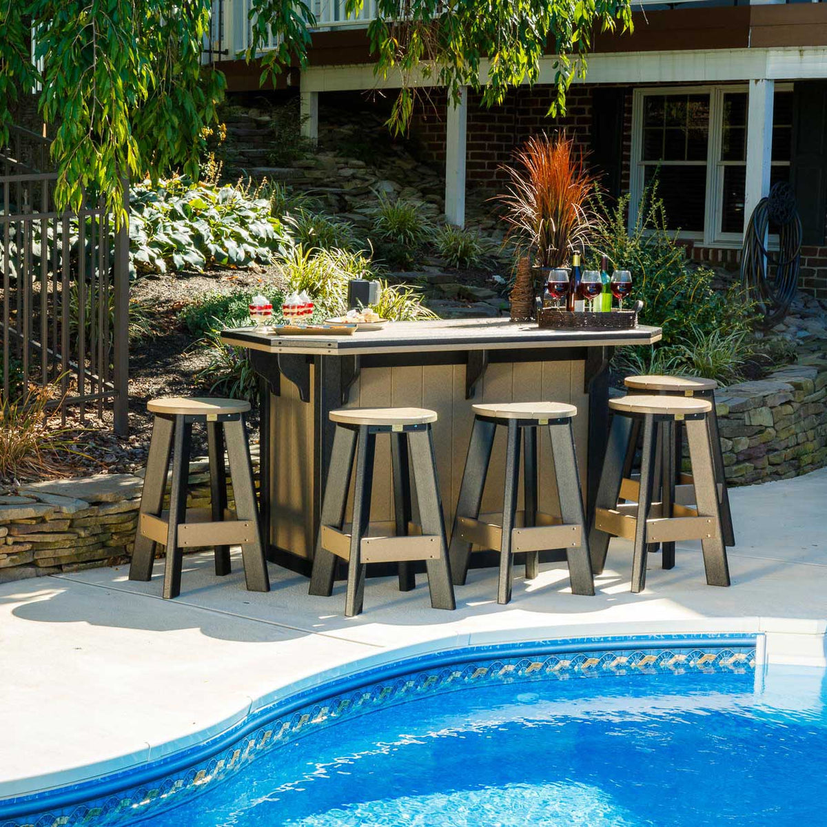Poolside outdoor bar island in weathered wood and black poly with six backless swivel bar stools