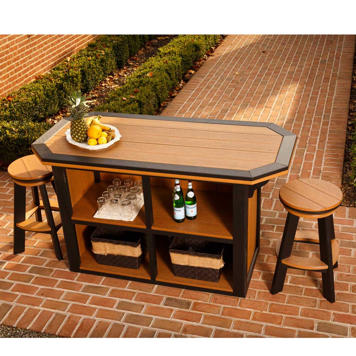 Outdoor bar island in cedar and black poly with open shelving stocked with glassware and baskets, shown with two swivel bar stools
