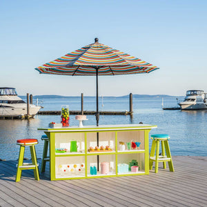 Back view of the white and lime green outdoor bar showing six open storage cubbies stocked with party supplies dockside