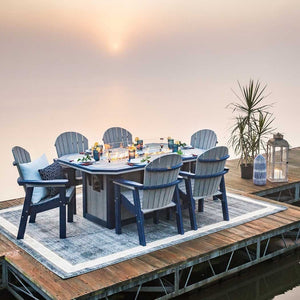 Gray and navy poly fire pit dining table for six with lanterns and a palm on a dock at sunrise