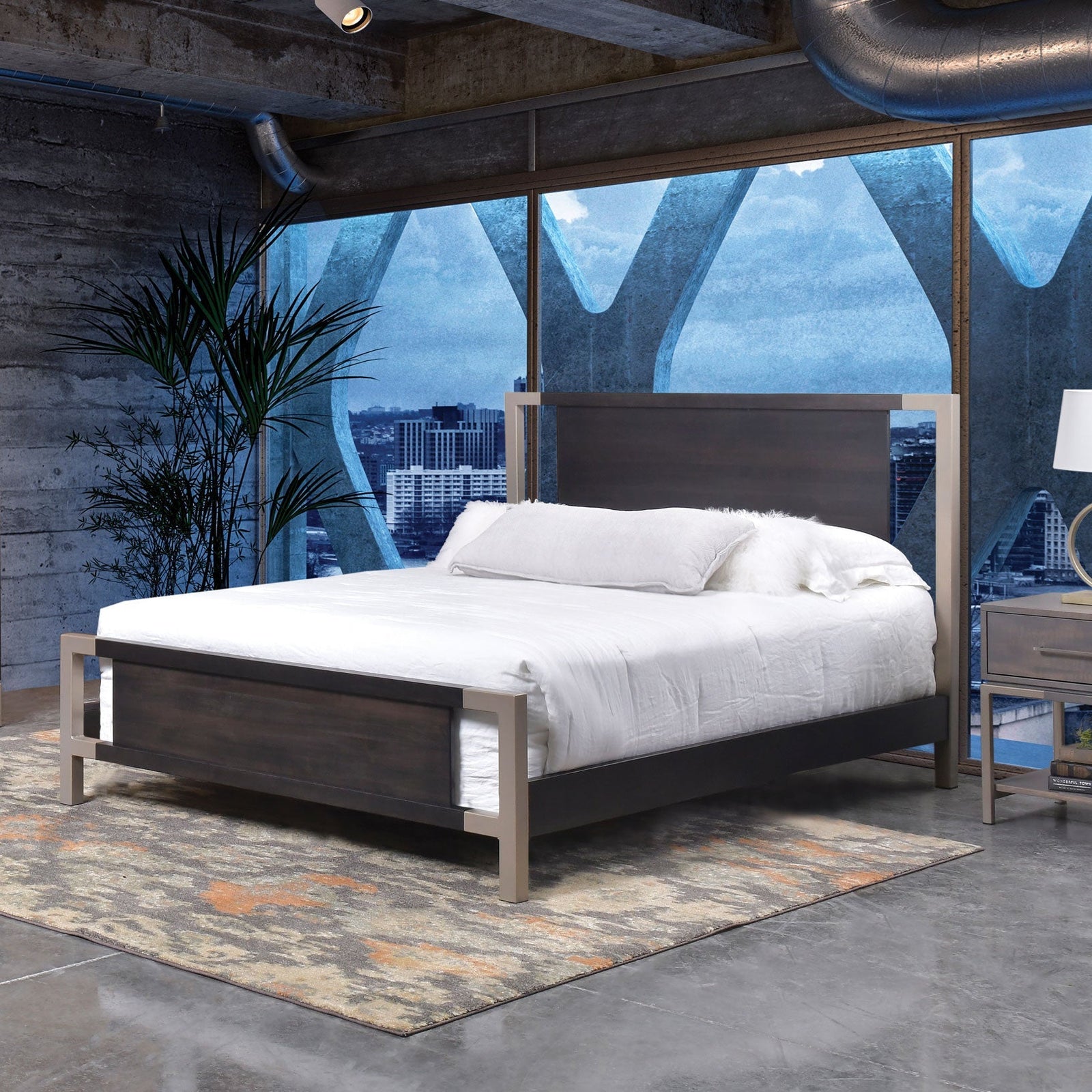 Metal-framed platform bed with a dark wood headboard and footboard panels and white bedding in a city loft