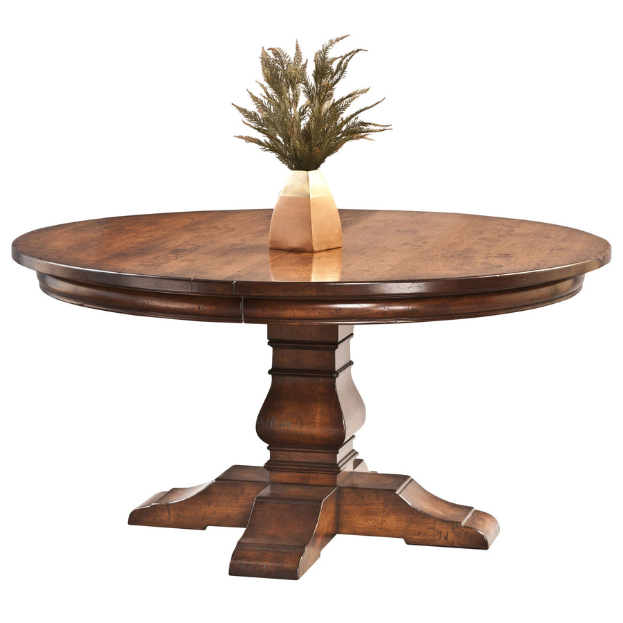 Round expandable pedestal dining table in rustic cherry with a turned column and four scrolled feet