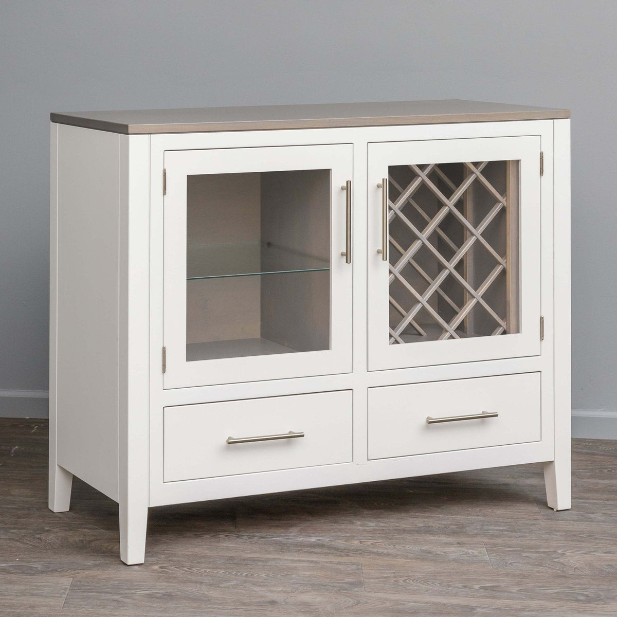 White painted wine storage server with a gray top, glass doors showing a lattice wine rack and shelf, and two drawers